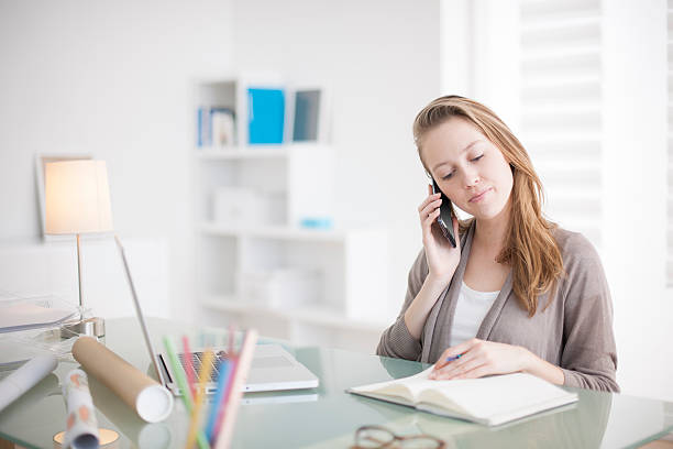 istock beautiful young woman on the workplace using his phone 475212326