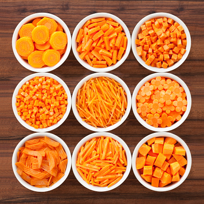 Nine bowls containing carrot cut in a variety of ways