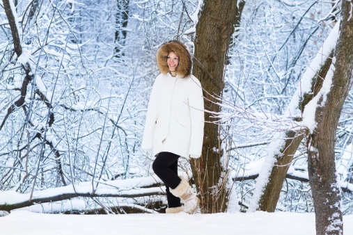 Beautiful young woman walking in a snowy park