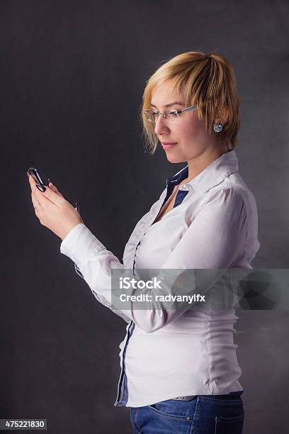 Business Woman With Phone Isolated On Dark Background Stock Photo - Download Image Now
