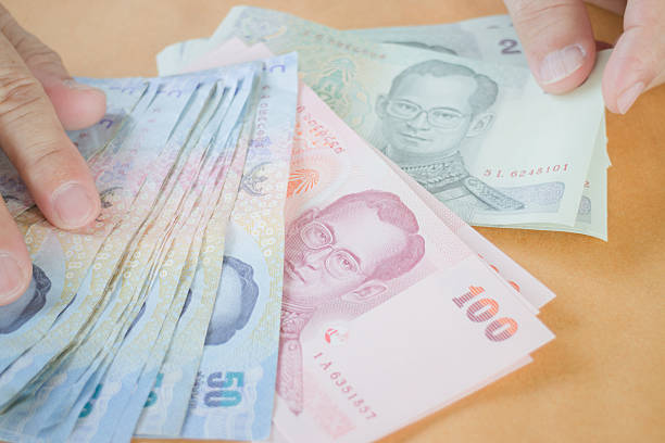 istock Man hand counting Thai baht banknote 475222996