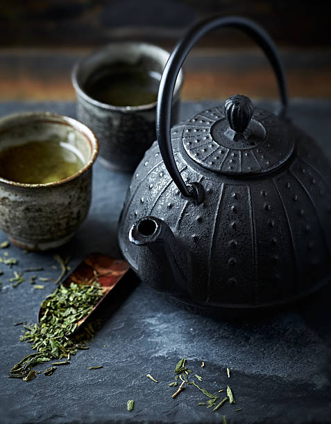 istock Cast iron tea pot and green tea in ceramic cups 475224366