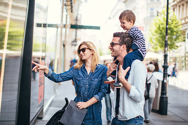 Family shopping Photo of young happy family shopping around the city window shopping stock pictures, royalty-free photos & images