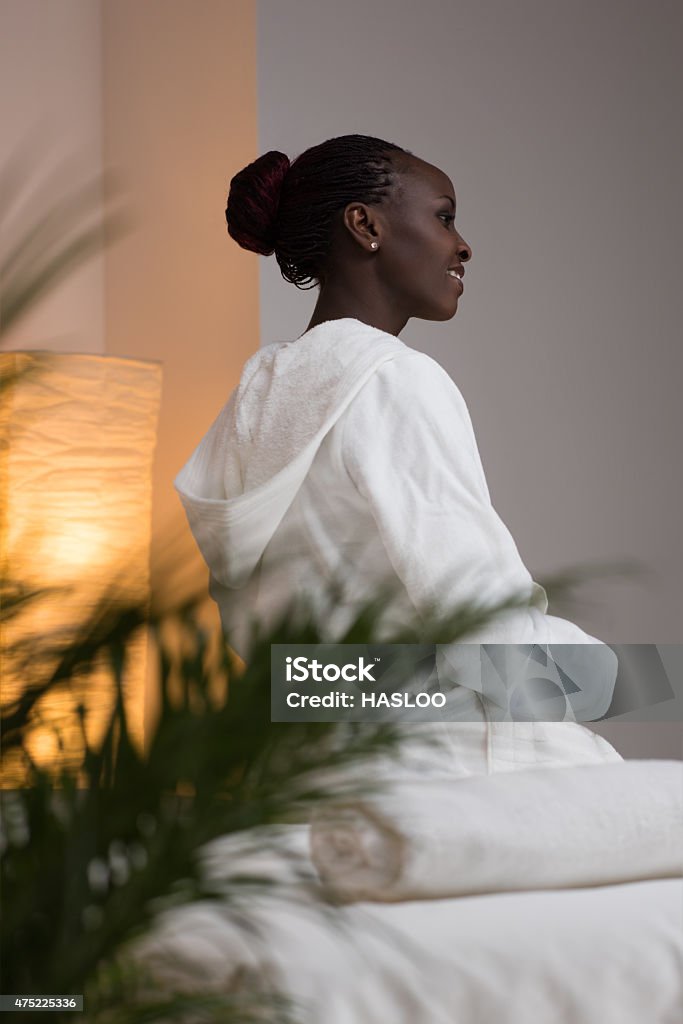 Woman at beauty spa salon Young pretty african woman sitting at beauty spa salon wearing bathrobe 2015 Stock Photo