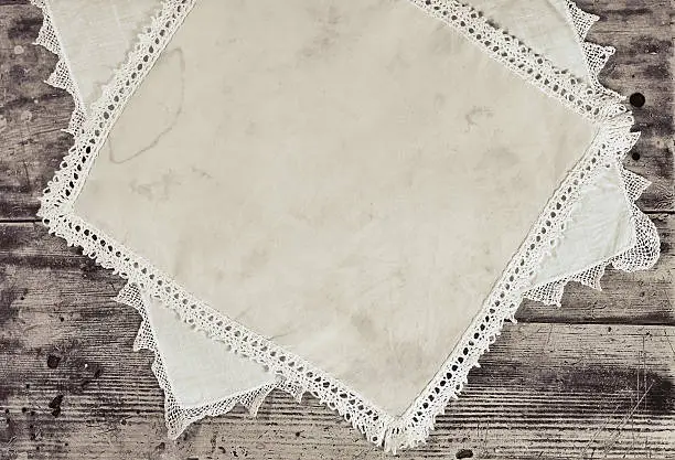 old vintage kerchiefs with stains on grunge wooden background. monochrome