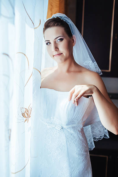 istock beautiful bride getting ready in white wedding dress with hairstyle 475230170