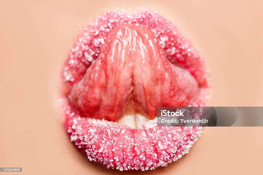 Toungue licking sugar from lips Alluring opened red lips of a girl with toungue licking sugar closeup, horizontal picture Human Sexual Behavior Stock Photo