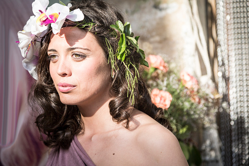 Young beautiful woman with a wreath of white flowers,