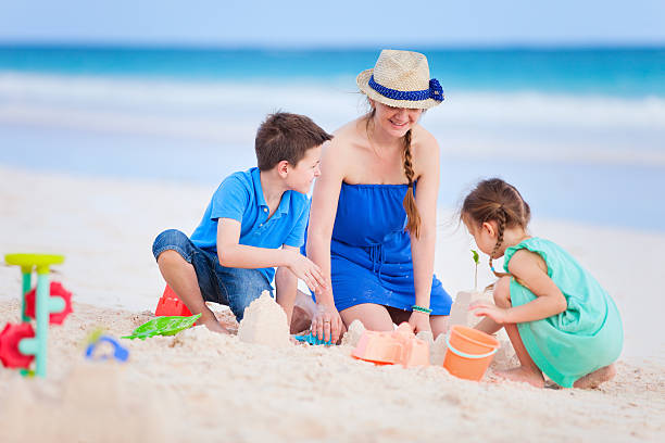 istock Mother and kids playing at beach 475238305
