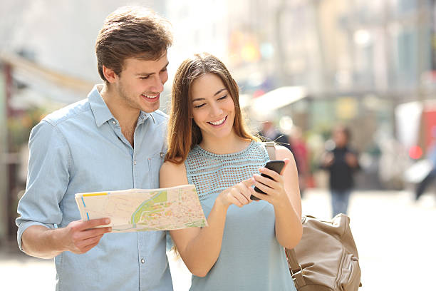 pareja de turistas consultar la guía de la ciudad y smartphone gps - tourist map men holding fotografías e imágenes de stock