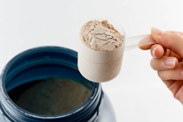 istock The hand raise a spoon measure Whey protein. 475243312