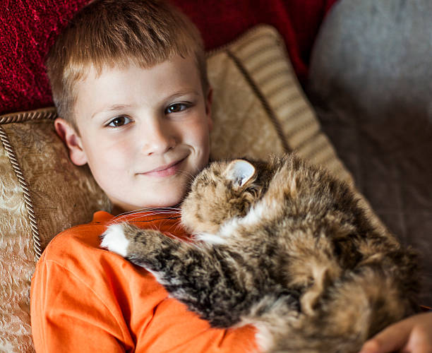 istock Boy and persian cat  together on the couch 475243922