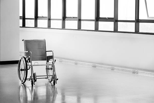 Blurred empty wheelchair at hallway in hospital at night for service patient and disabled people. Medical equipment in hospital for assistance handicapped people. Chair with wheels for patient care.