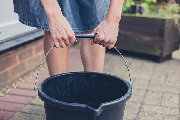 Woman lifting bucket in garden stock photo