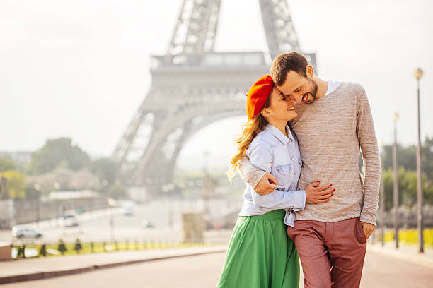 Romance in Paris Young loving couple sharing their love and affection in front of the Eiffel tower in Paris, France.  paris france eiffel tower love kissing stock pictures, royalty-free photos & images