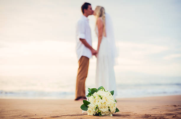 istock bride and groom on beach at sunset 475253977