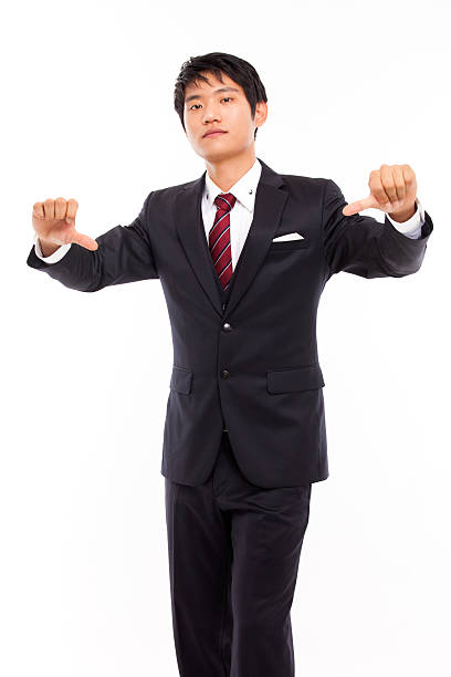 Young Asian business man show bed sign Young Asian business man show bed sign isolated on white background. asian suit man cross hand stock pictures, royalty-free photos & images