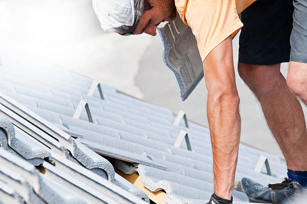 istock Tiler covering roof with new tile 475256342