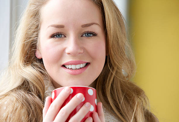 istock Smiling woman holding cup of tea 475258263