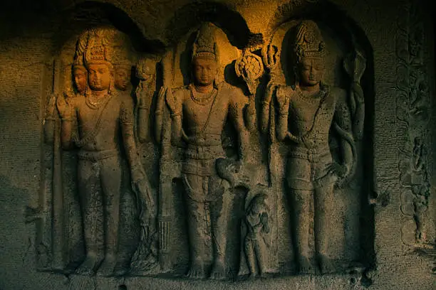 These are the 13th century hand carved hindu deities in a remote part of Ellora Cave Complex, Maharashtra, India. Taken at sunset and crimson light just kisses the statues just before dark.