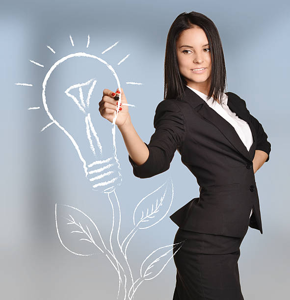 istock Woman draws bulb light tree standing on abstract background 475269060