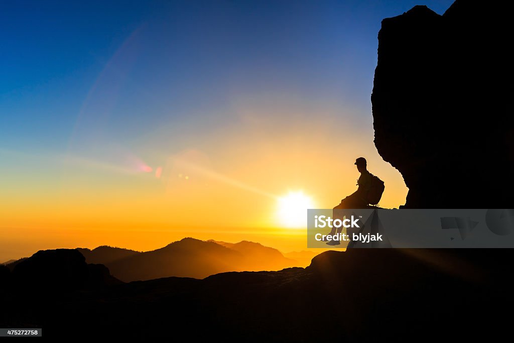 Man hiking silhouette in mountains sunset freedom Man hiking silhouette in mountains, sunset and ocean. Male hiker with backapck on top of mountain looking at beautiful night landscape view and blue sky, freedom concept 2015 Stock Photo