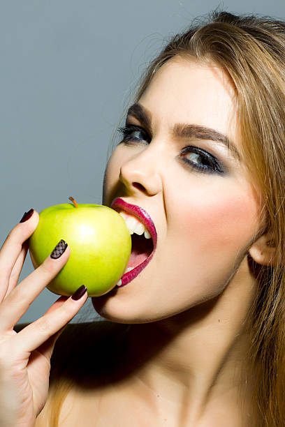 istock Passionate blonde girl with apple 475273540