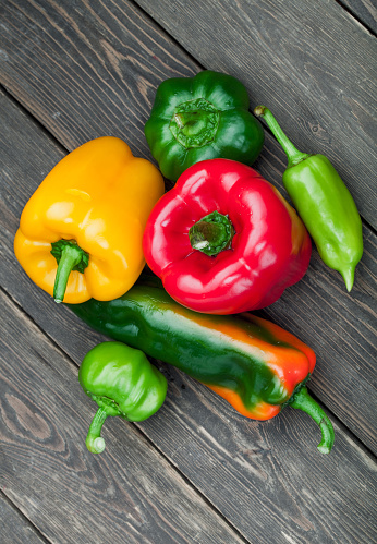 Three sweet peppers, wooden table background