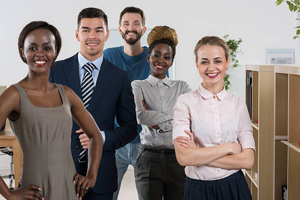 istock Happy business team standing together at office 475281694