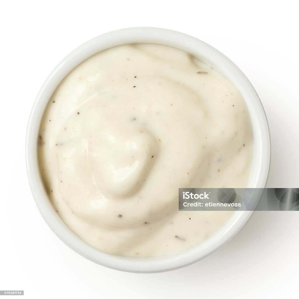 Small pot of garlic mayonnaise, isolated, detail, from above. Aioli Stock Photo