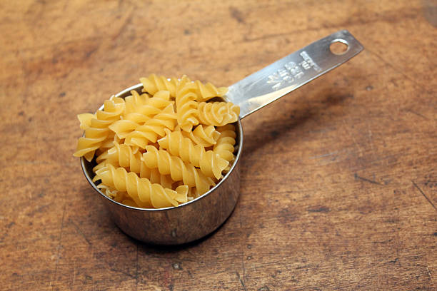 Pasta in measuring cup stock photo
