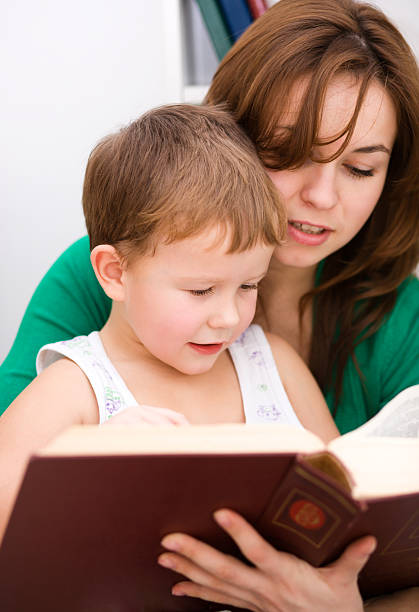 istock Mother is reading book with her son 475283631