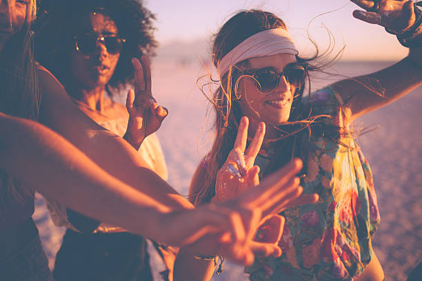 niñas bailando en una beachparty al atardecer - hippy fotografías e imágenes de stock