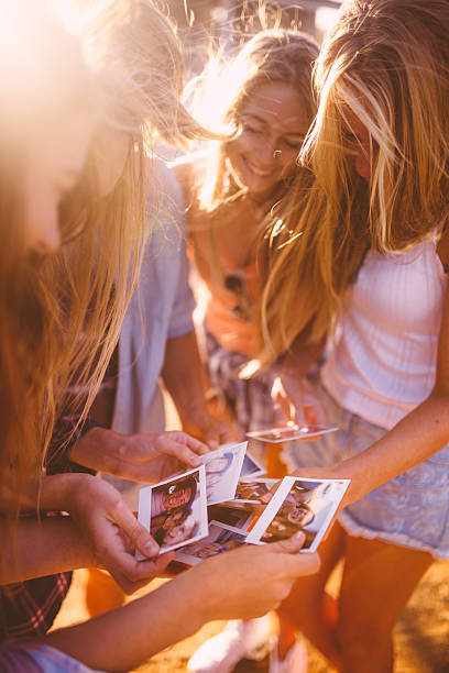istock Group of teens sharing instant photographs 475285042