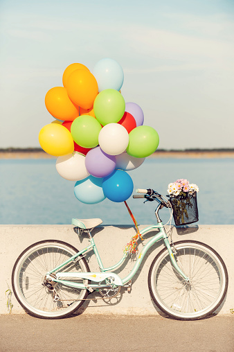 Picture of vintage bicycle with balloons and flowers in basket
