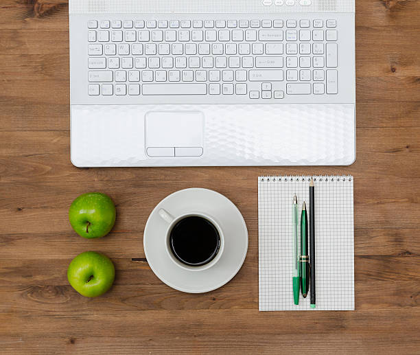 istock green apples on worplace with notebook, coffee  and pens 475290920