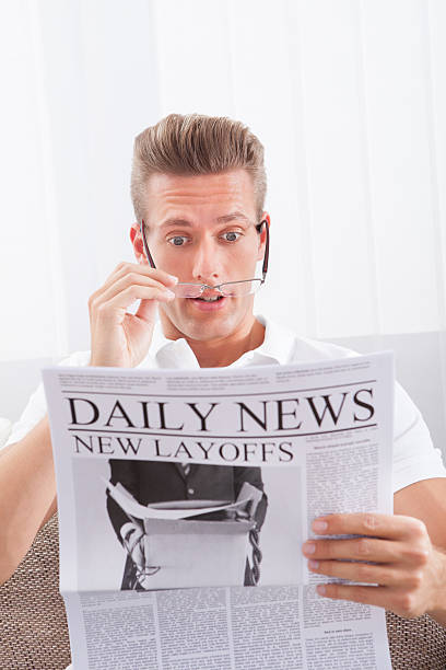 istock Reading Newspaper With The Headline New Layoffs 475294032