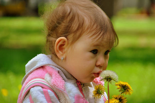 istock Little girl blowing on a dandelion 475294334