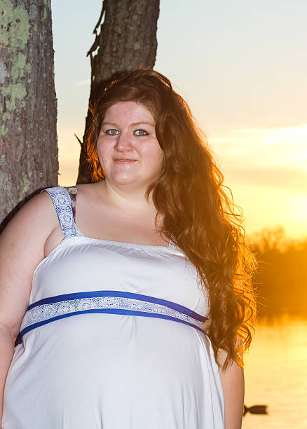 istock Pregnant Woman Poses by Tree at Sunset 475294476