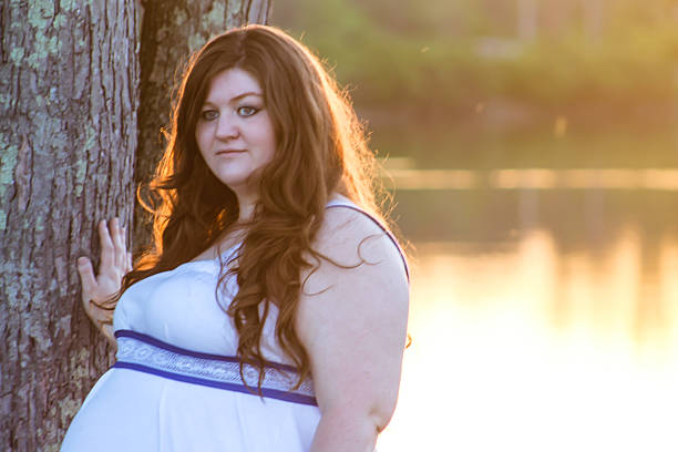 istock Pregnant Woman Poses by Tree 475294484