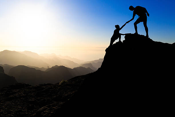 o trabalho em equipe casal caminhadas ajuda - mountain climbing rock climbing adventure incentive - fotografias e filmes do acervo