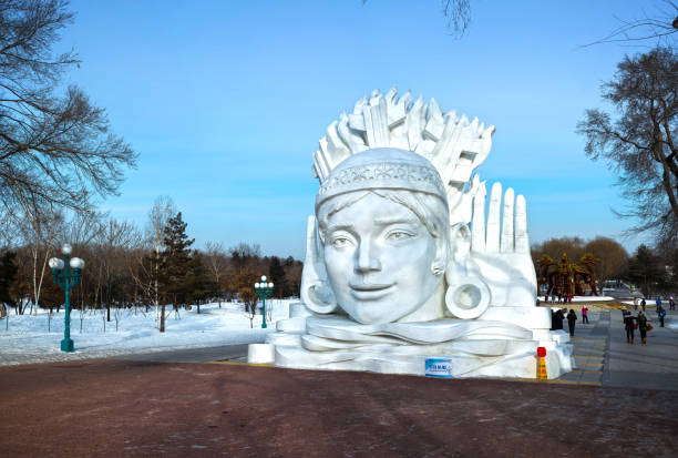 Harbin, China - January 9, 2014: Snow Girl sculpture. People are walking. Located in Sun Island Park of Harbin City, Heilongjiang Province, China.