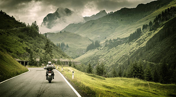 montagnes motard débarquant sur l'autoroute - motorcycle road journey travel photos et images de collection