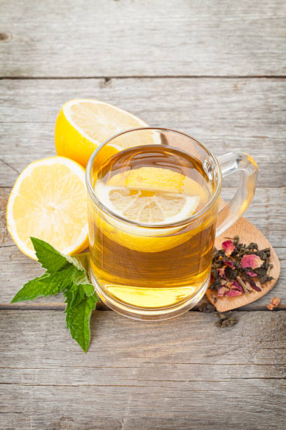 istock Green tea with lemon and mint on wooden table 475300654