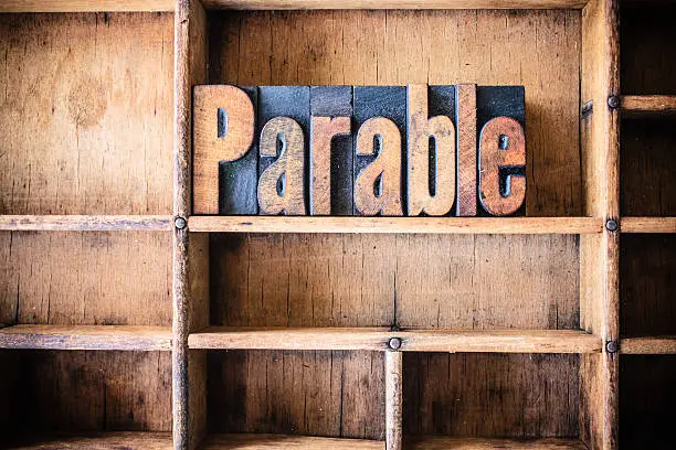 The word PARABLE written in vintage wooden letterpress type in a wooden type drawer.