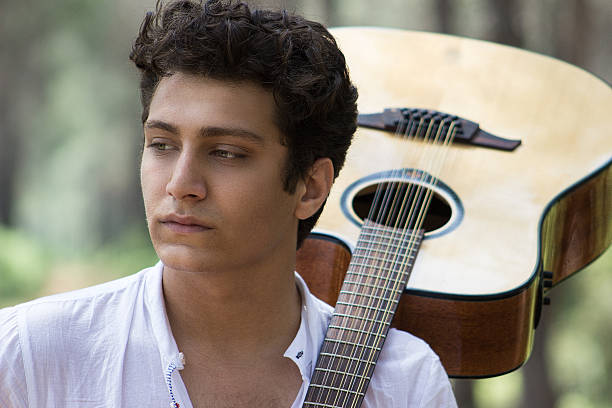 istock Young man with acoustic guitar 475308396