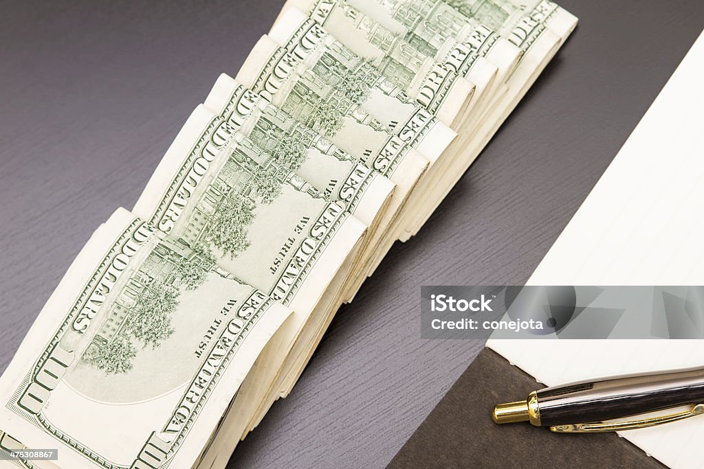 Dollars with a copybook Lots of dollars with an open copybook Bank Account Stock Photo