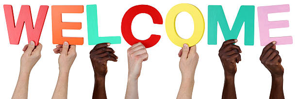 istock Multi ethnic group of people holding the word welcome 475311498