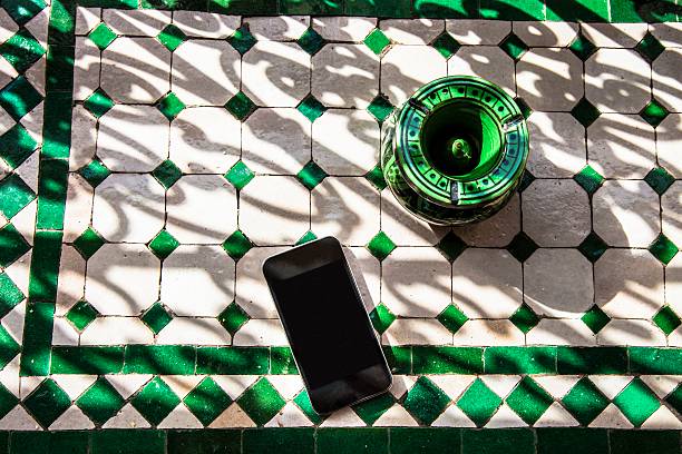ブラックの携帯電話の花輪を施したモロッコ風テーブル - lying on the floor ストックフォトと画像