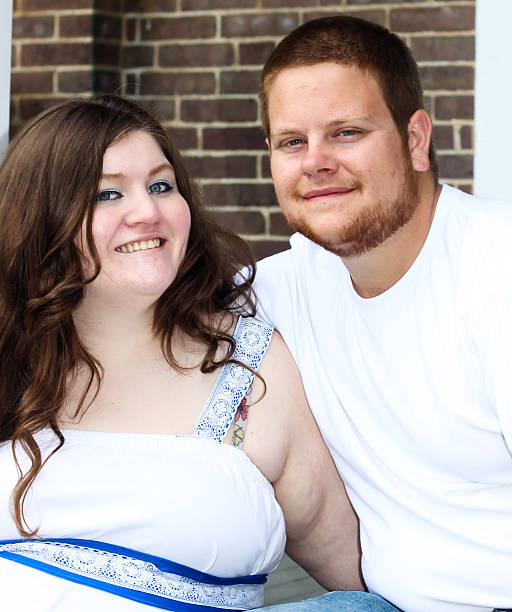 Husband and Wife Posing in Front of Brick Wall